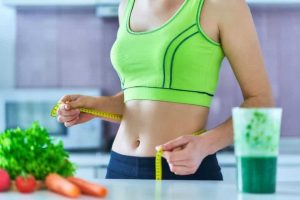 Uma mulher medindo a cintura depois de saber como emagrecer rápido e perder barriga