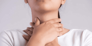 Menina com afta na garganta