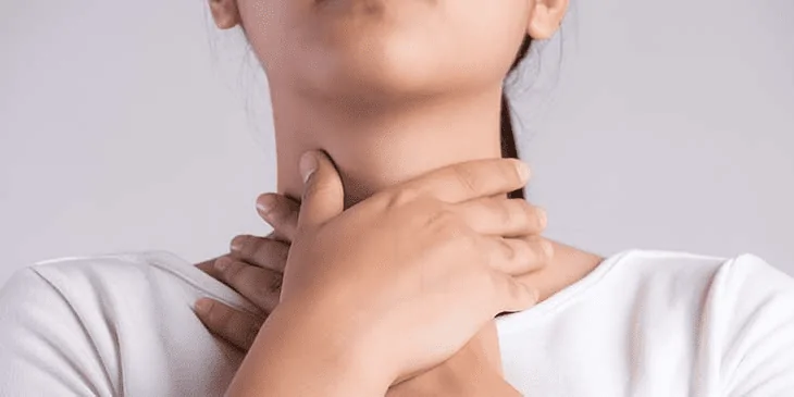 Menina com afta na garganta