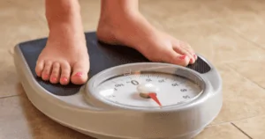 Uma pessoa se pesando para encontrar uma maneira de perder peso rápido