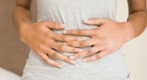 Uma pessoa com a mão na barriga precisando descobrir o que é bom para gases