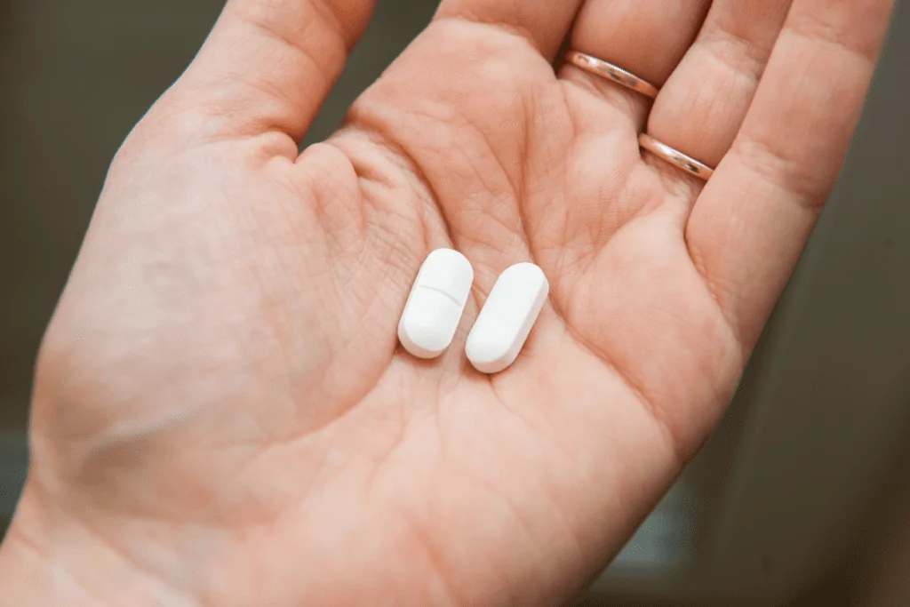 Uma pessoa segurando comprimidos de cetoprofeno para que serve