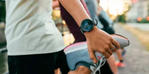 Pessoa fazendo um alongamento com um dos melhores relógios para corrida no pulso