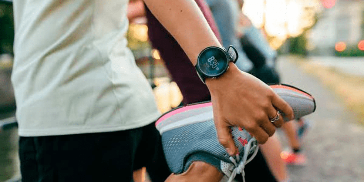 Pessoa fazendo um alongamento com um dos melhores relógios para corrida no pulso