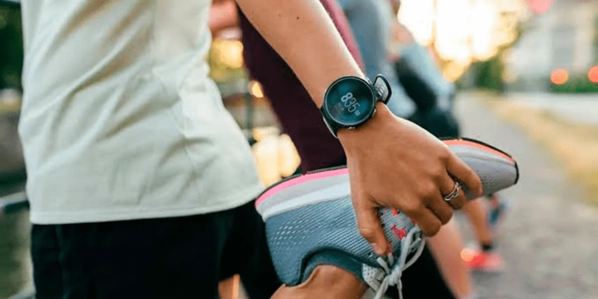 Pessoa fazendo um alongamento com um dos melhores relógios para corrida no pulso