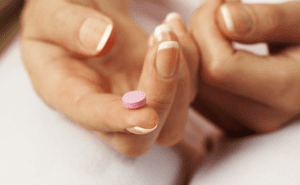 Uma pessoa tomando a pílula do dia seguinte