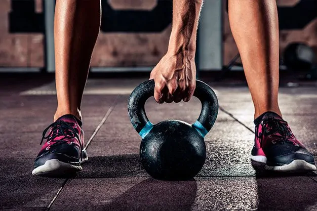 Uma pessoa segurando um haltere enquanto faz exercício