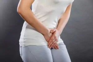 Uma pessoa sentindo desconforto na região da bexiga.