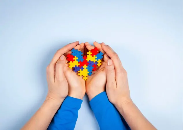 Mãos de pai e filho montando quebra-cabeça juntos para ilustrar a importância do papel dos pais no desenvolvimento infantil de uma criança com autismo