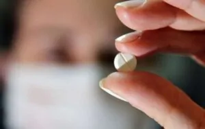 Uma pessoa segurando uma capsula de zolpidem