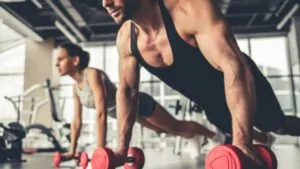 Homem fazendo flexão unilateral peito com halteres