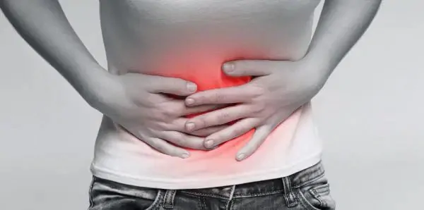 Uma mulher precisando de remédio para dor de barriga