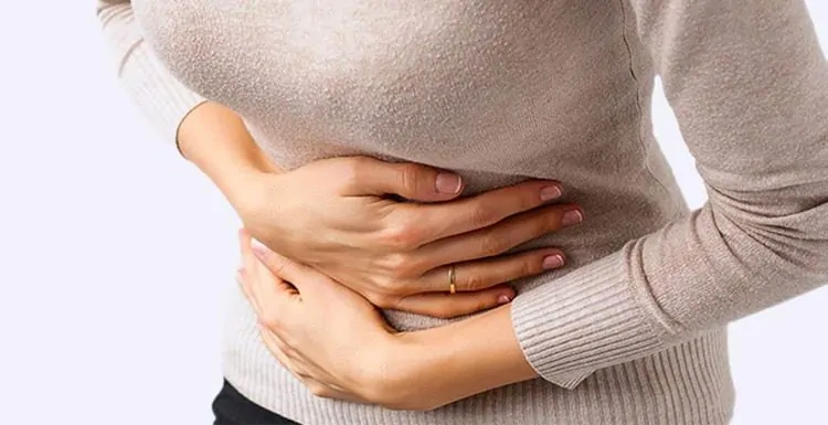 Uma mulher precisando de remédio para dor de barriga