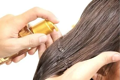 mulher aplicando óleo vegetal para cabelo
