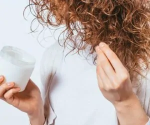 Mulher passando o melhor creme para cabelo cacheado