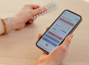 Mulher olhando calendário menstrual no celular