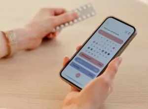 Mulher olhando calendário menstrual no celular