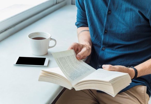 Homem lendo livros de autoajuda