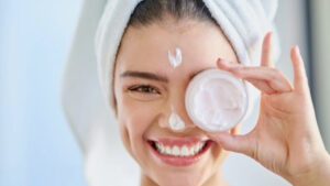 imagem de uma mulher aplicando creme para o rosto