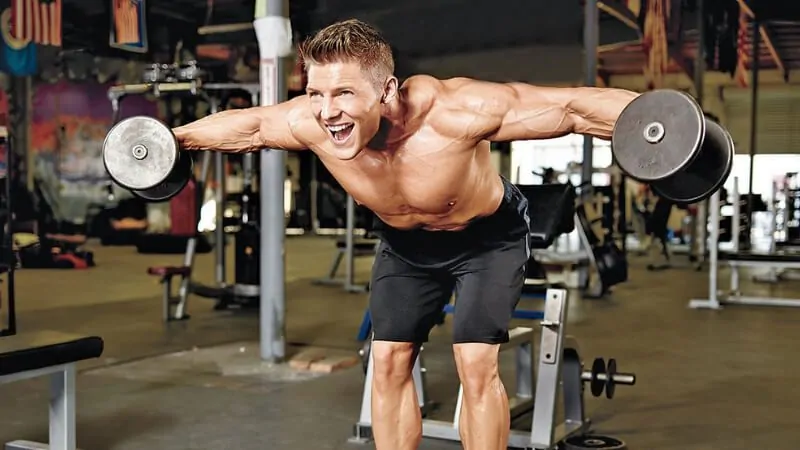 imagem com um homem fazendo crucifixo inverso para treino de ombros