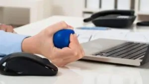 imagem com uma mão apertando uma bolinha anti stress
