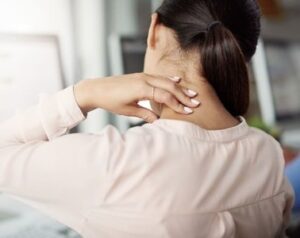 Mulher precisando de remédio de torcicolo