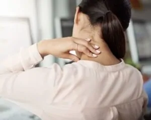 Mulher precisando de remédio de torcicolo