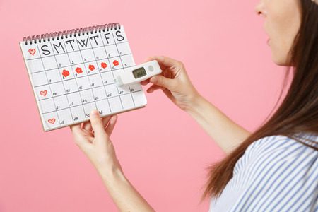 Mulher analisando a data da injeção anticoncepcional no calendário