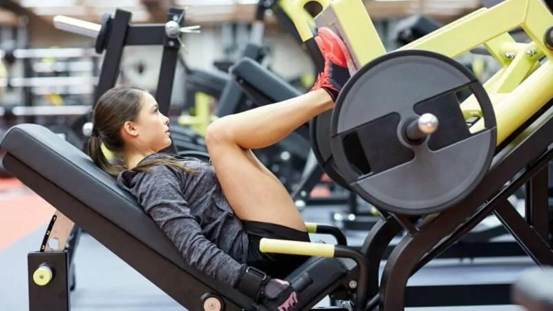 mulher fazendo exercício no leg press