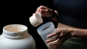 imagem com uma mulher preparando o whey protein