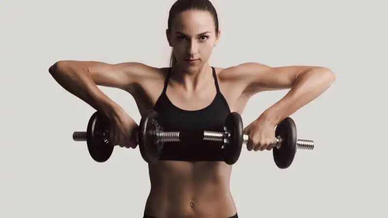 imagem com uma mulher fazendo remada alta para treinar os ombros