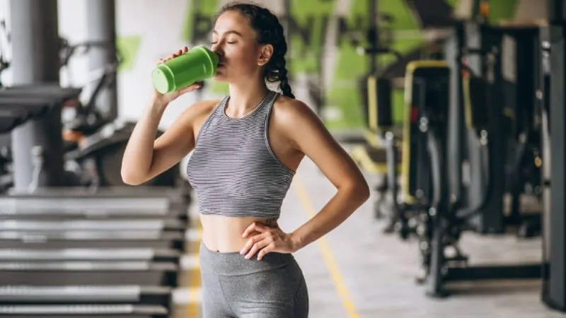 imagem com uma mulher tomando proteína