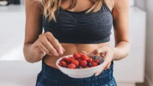 imagem com uma mulher comendo saudável e a importância de utilizar a calculadora de calorias