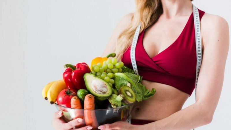 imagem de uma mulher com vários legumes nas mãos