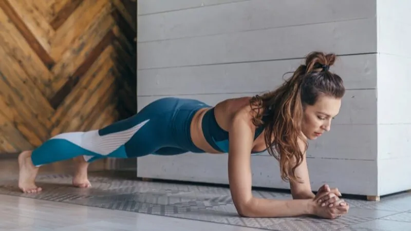 imagem de uma mulher fazendo prancha para diminuir a barriga