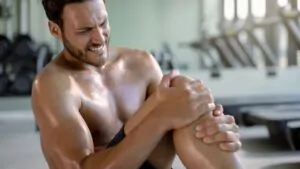 imagem de um homem tendo cãibra na perna