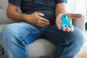 Homem com câncer de próstata segurando um laço em azul