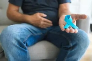 Homem com câncer de próstata segurando um laço em azul