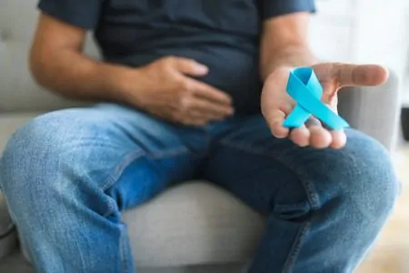 Homem com câncer de próstata segurando um laço em azul