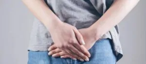 Homem com as mãos na região íntima