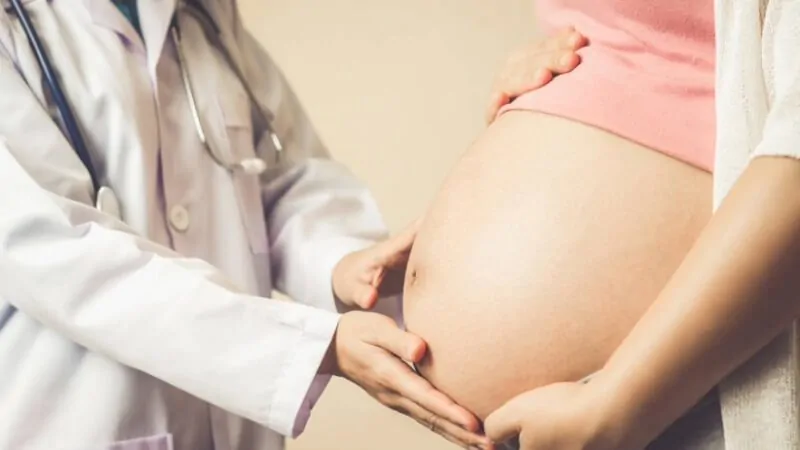 imagem de um médico examinando a barriga de uma paciente