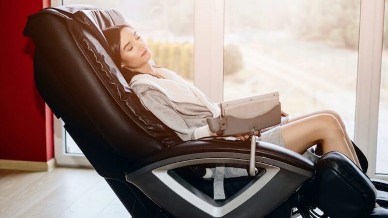 imagem de uma mulher sentada em uma cadeira de massagem
