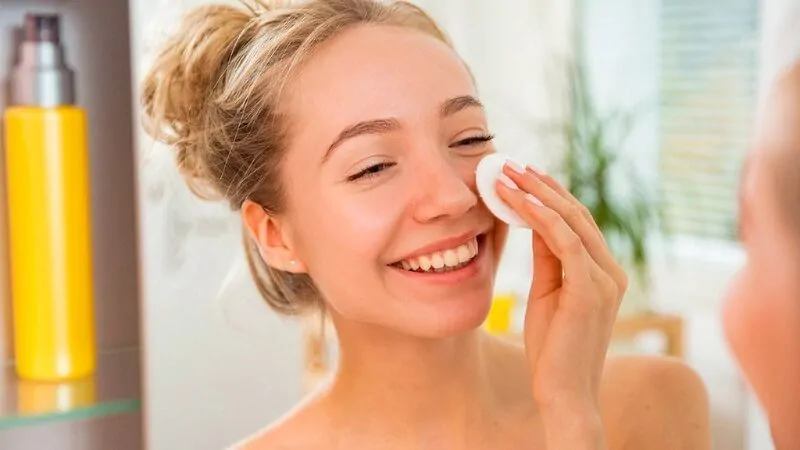 imagem de uma mulher aplicando tônico facial