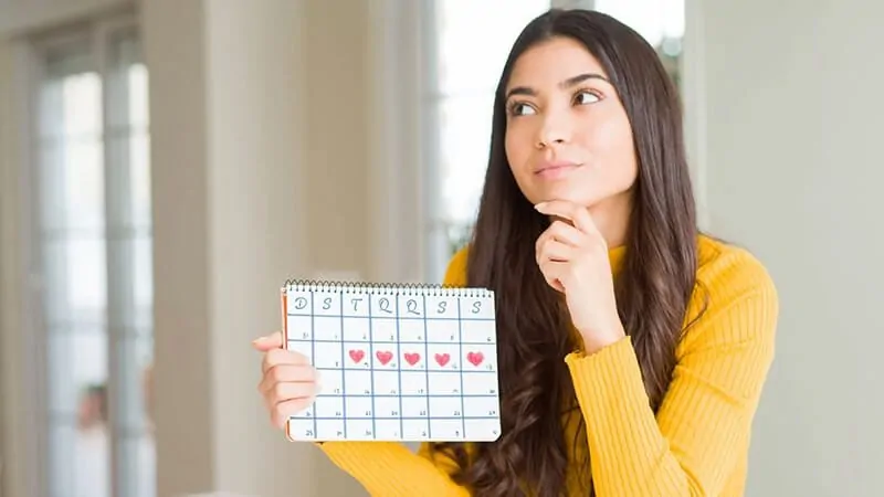 imagem de uma mulher segurando um calendário