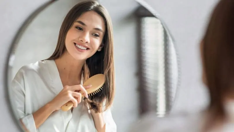 imagem de uma mulher penteando os cabelos