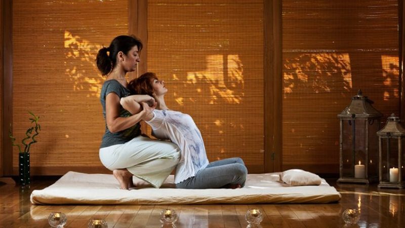 imagem de uma mulher se alongando com a massagem tailandesa