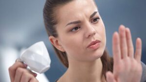 imagem com uma mulher olhando as unhas amareladas