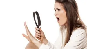 imagem com uma mulher olhando as unhas roxas