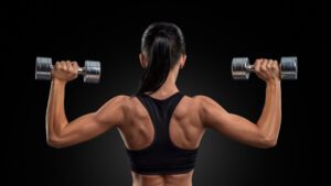 imagem de uma mulher realizando o exercício desenvolvimento com halteres