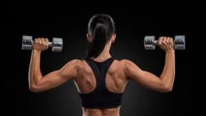 imagem de uma mulher realizando o exercício desenvolvimento com halteres